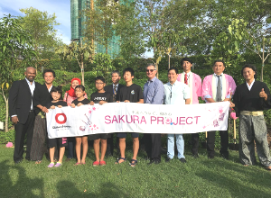 植樹した木の前でバナーをもって記念撮影する写真